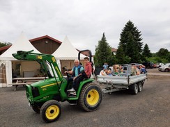 Foto von einem Trecker mit Anhänger mit vielen Teilnehmer:innen darin